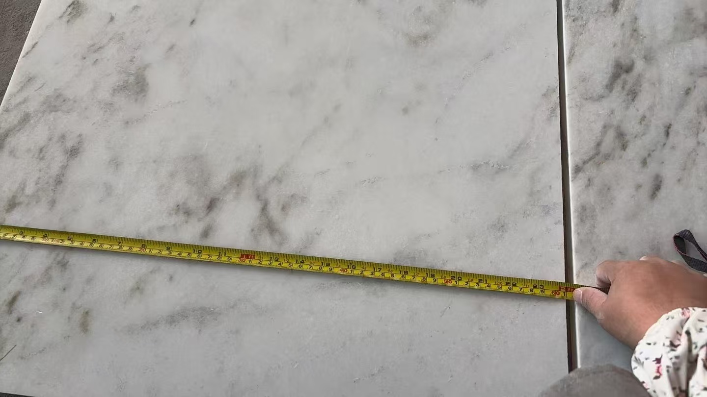 measuring marble tile dimension with tape during QC measuring marble tile dimension with tape during QC